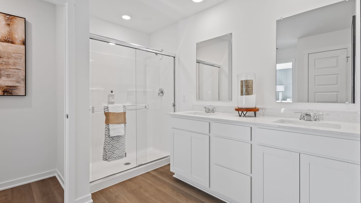 Primary bathroom with dual vanity sinks and a walk-in shower.