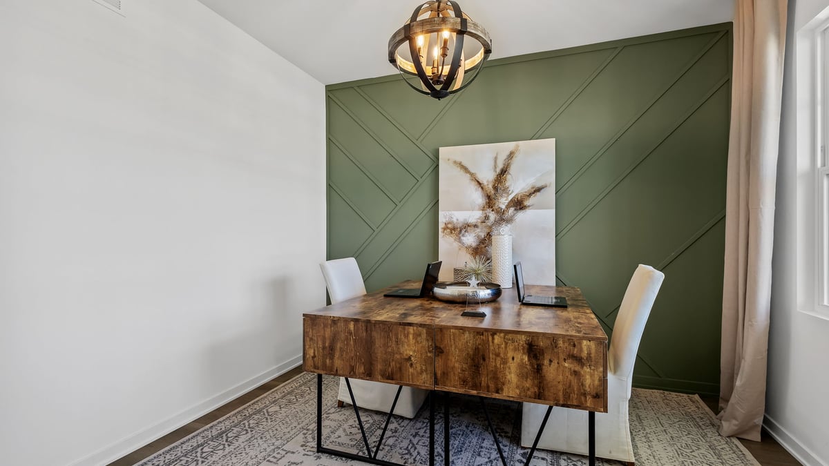 Front room staged as an office space with carpeted floors.