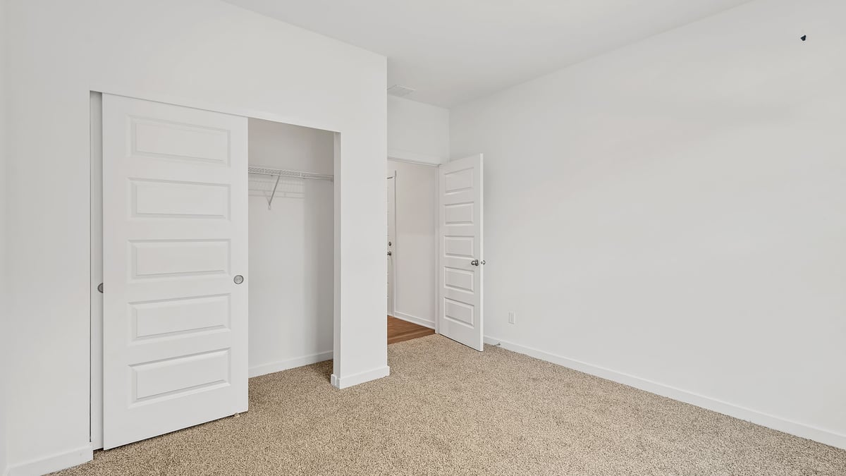 Bedroom with carpeted floors and a closet.