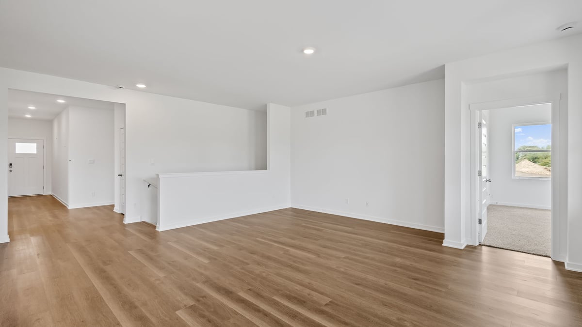Living room area with hard wood flooring and an open layout.
