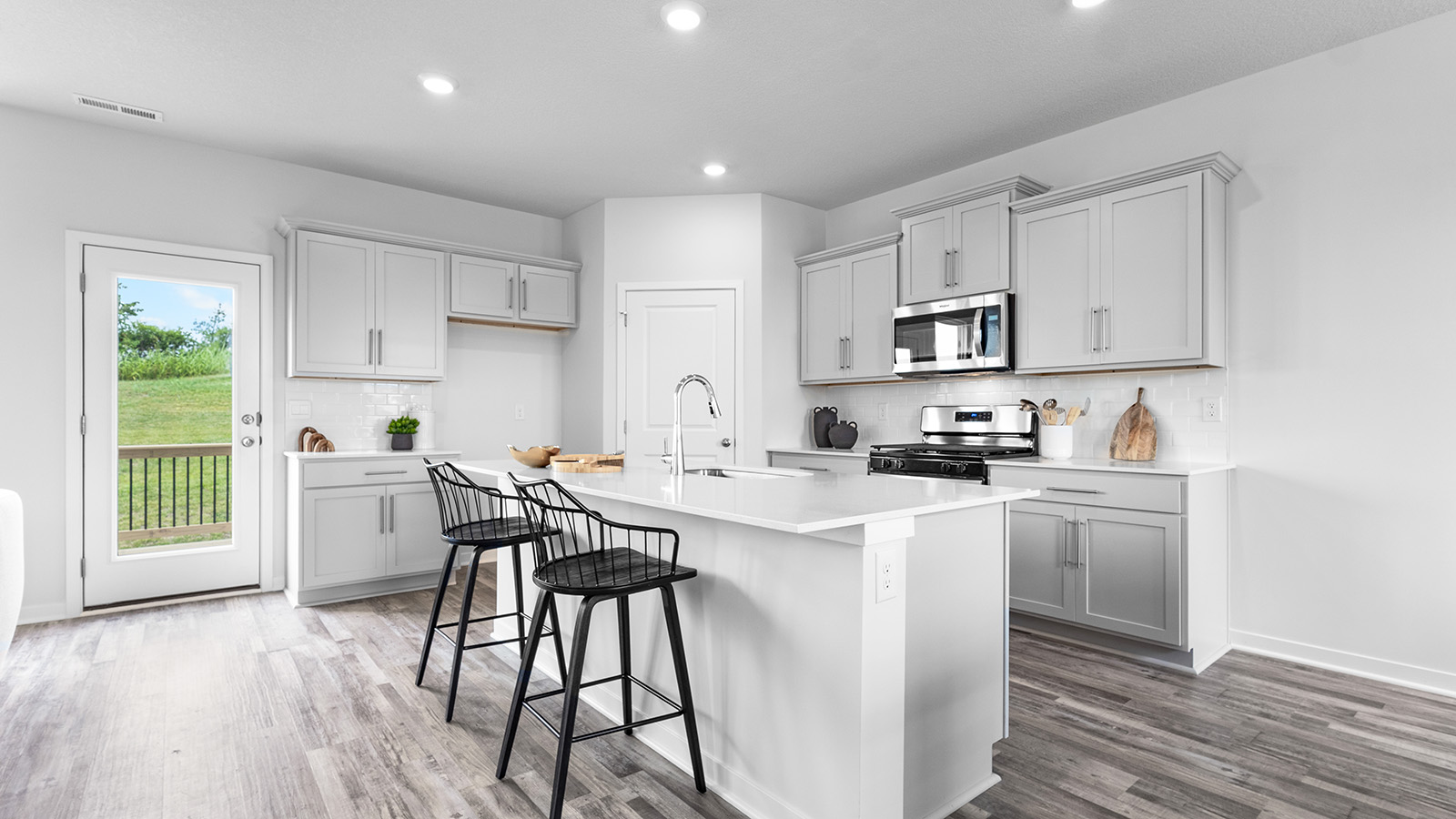 open concept kitchen with large island and stainless steel appliances.