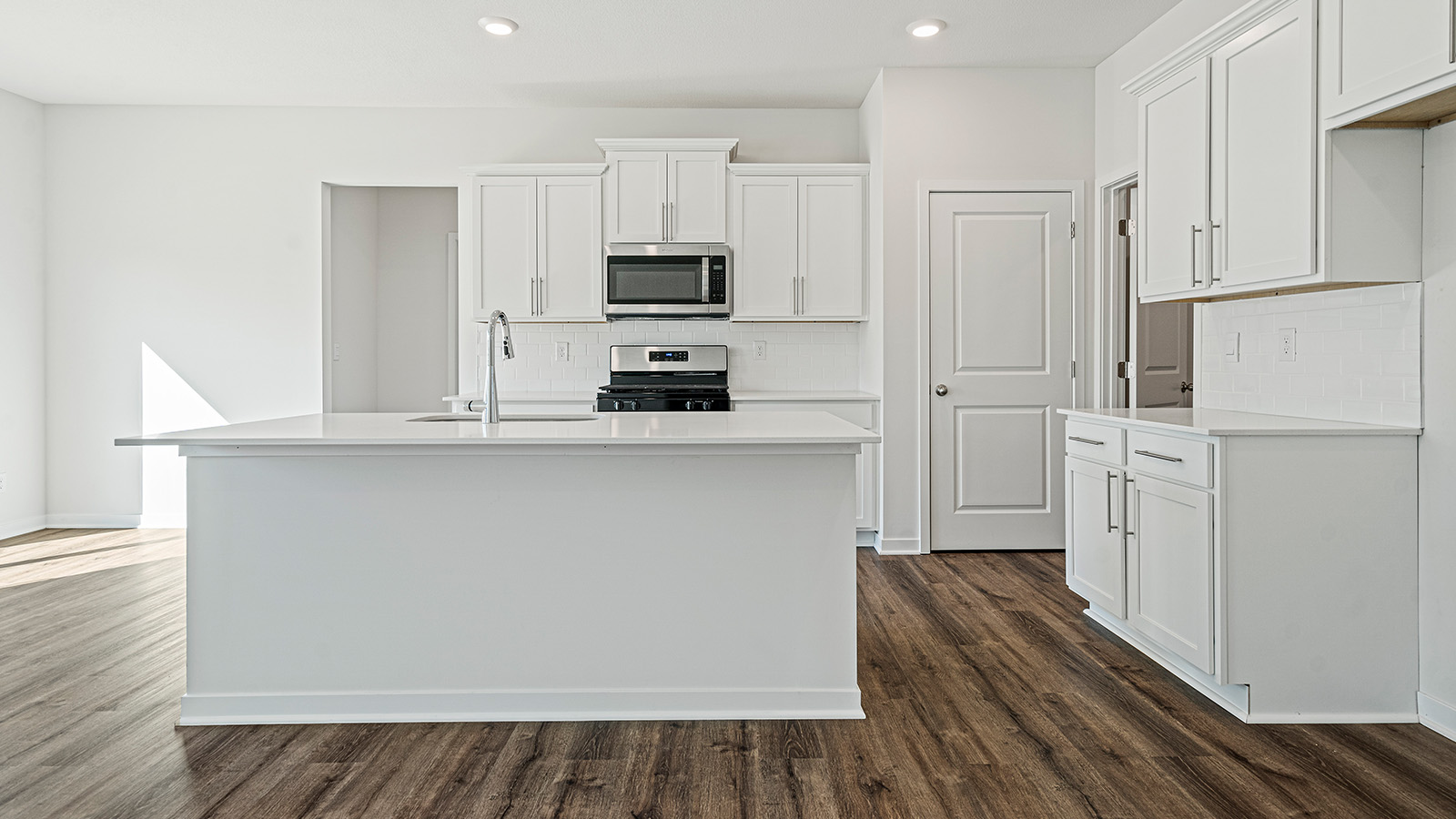 Kitchen with large Island, white cabinets and countertops