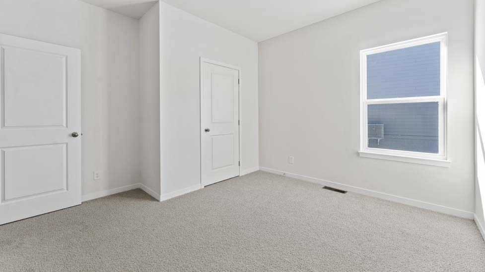 Carpeted bedroom with large window