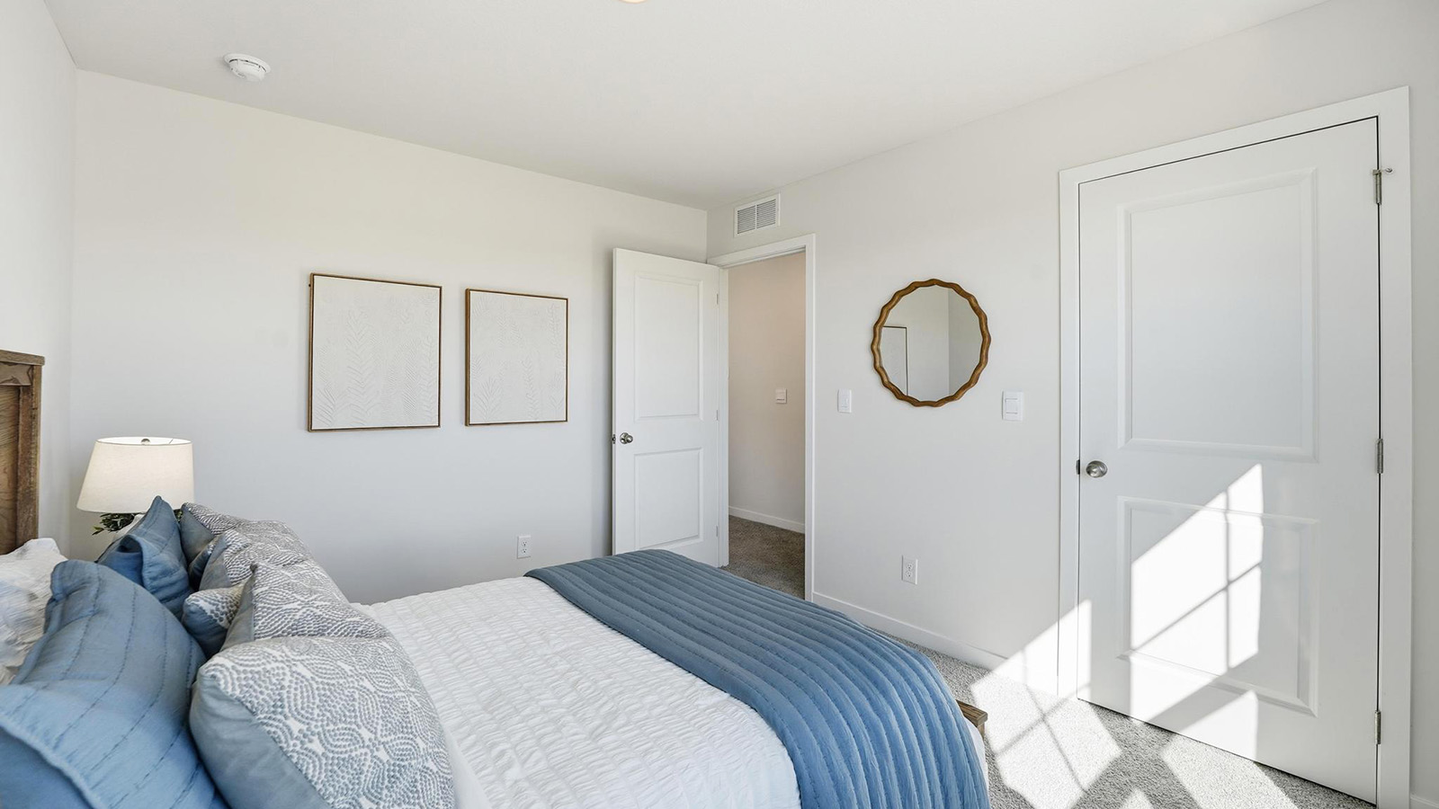 Carpeted bedroom with large window.