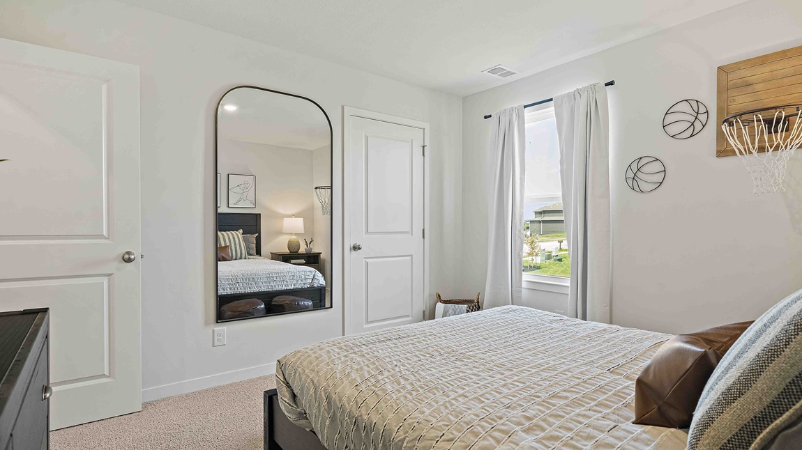 Carpeted bedroom with large window.