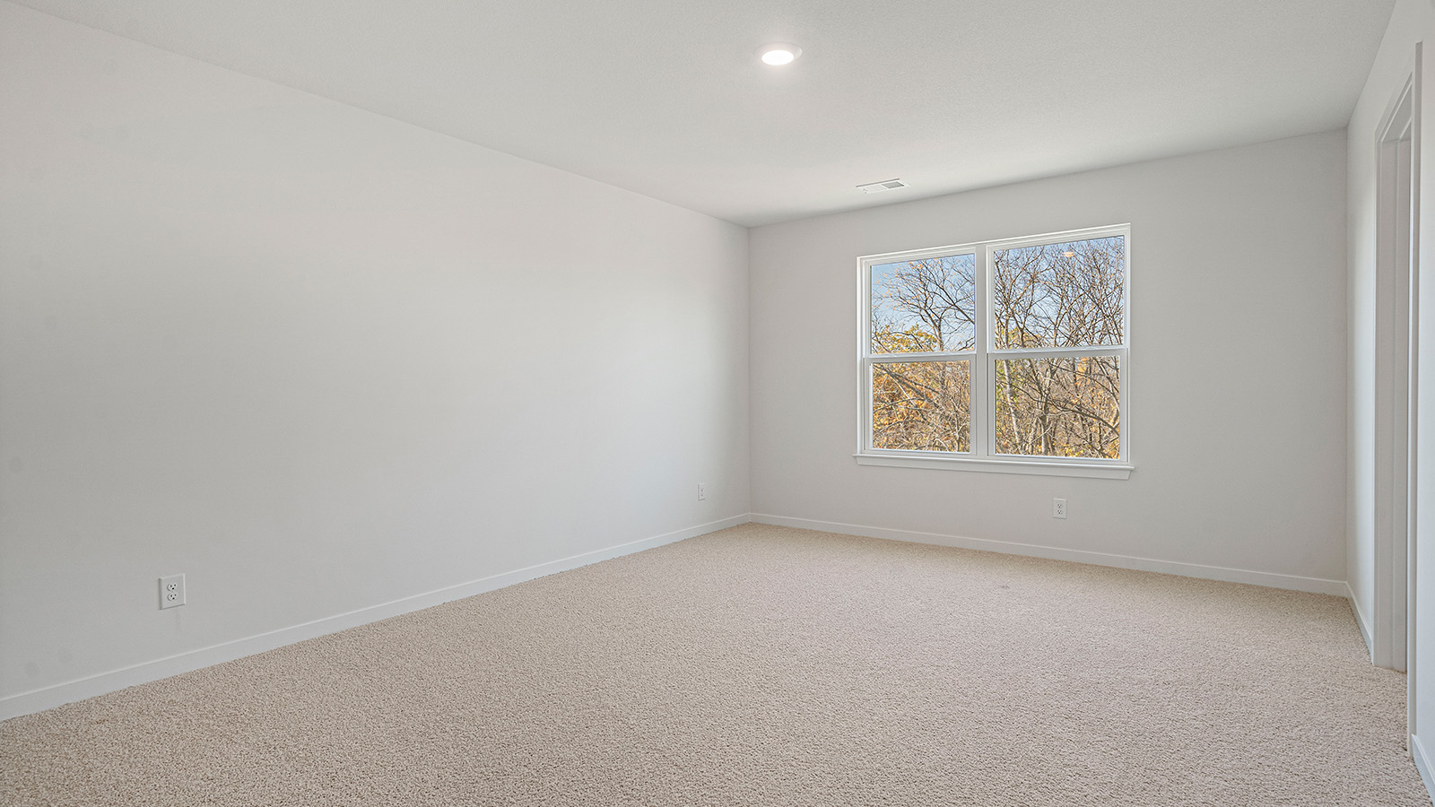 Primary carpeted bedroom carpeted with large window