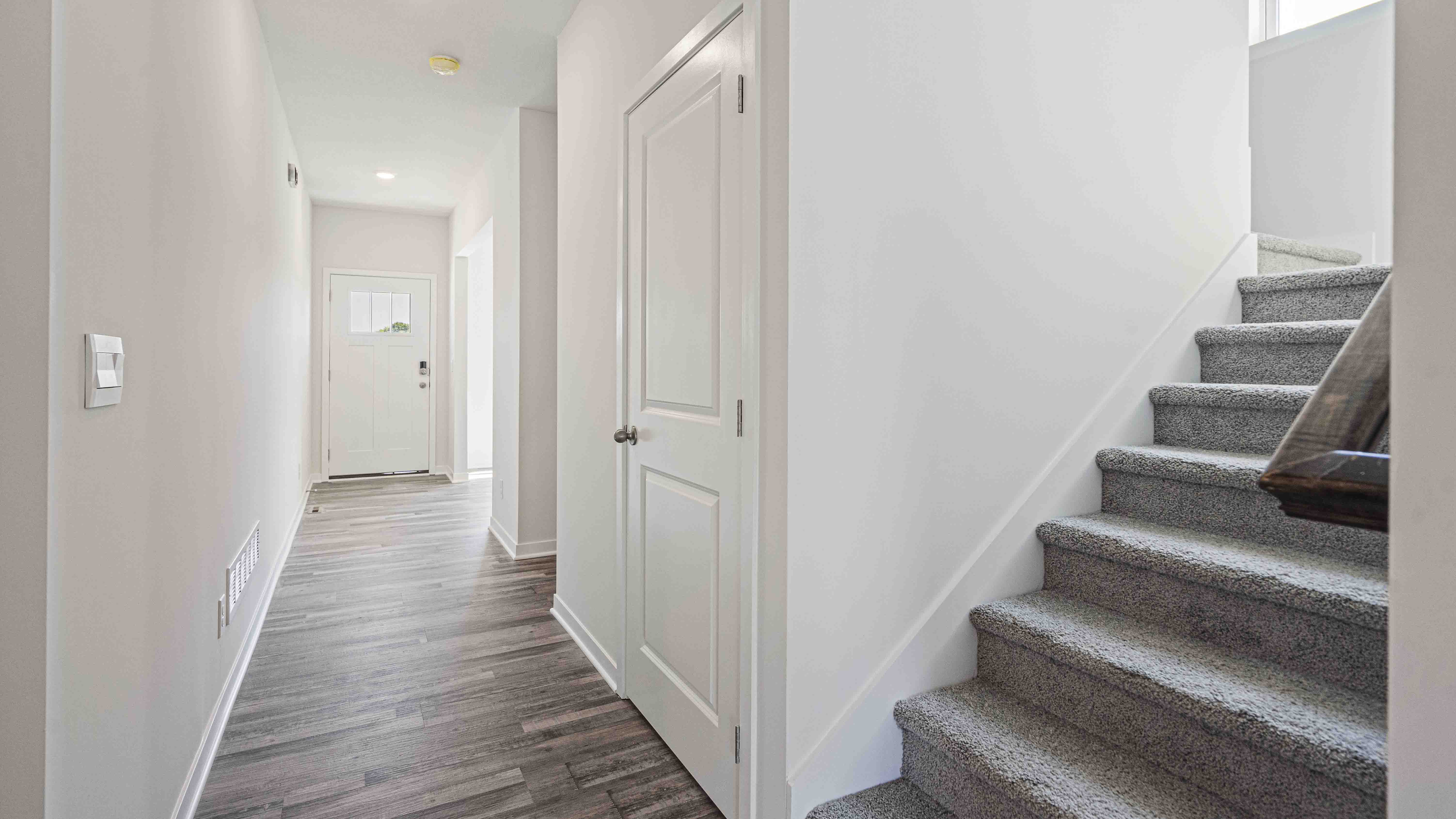 Welcoming foyer with view of carpeted staircase