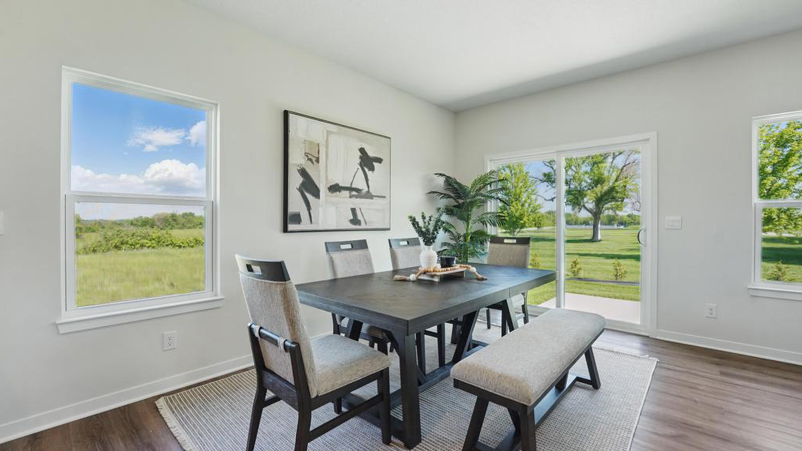 Dining area beside kitchen and living room with sliding glass back door and large window.