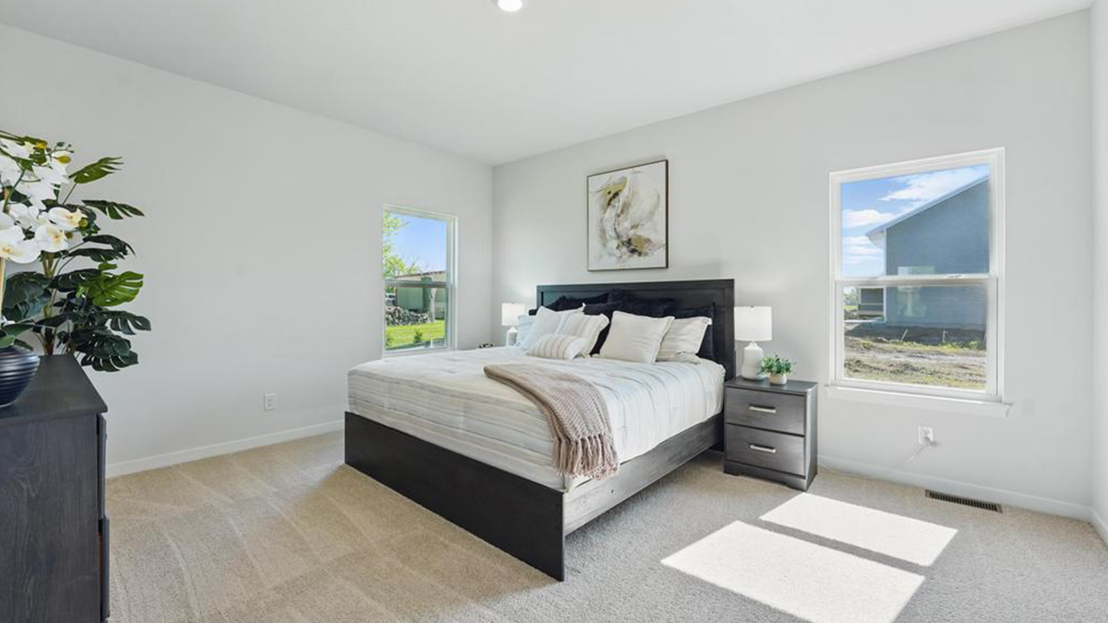 Primary bedroom with carpet and large window.