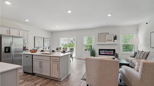 Kitchen and island with gray cabinets and stainless steel appliances. New Homes in Kansas City, Missouri