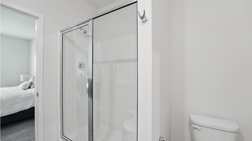Primary bathroom with standing glass Door shower. New Homes in Kansas City, Missouri