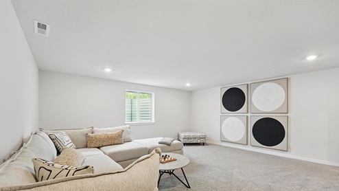 Carpeted upstairs loft area with large window