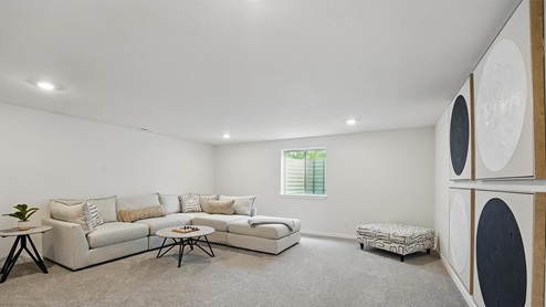 Carpeted upstairs loft area with large window