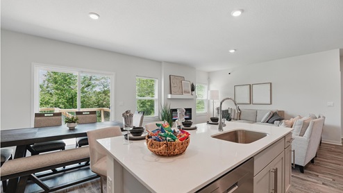 Kitchen and island with gray cabinets and stainless steel appliances. New Homes in Kansas City, Missouri