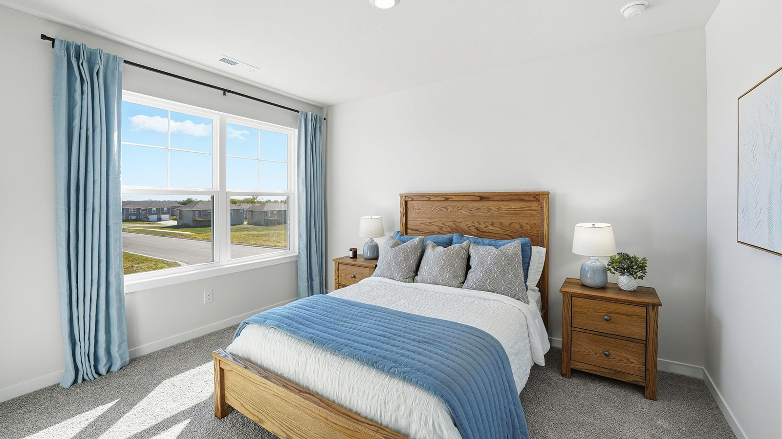 Carpeted bedroom with large window.