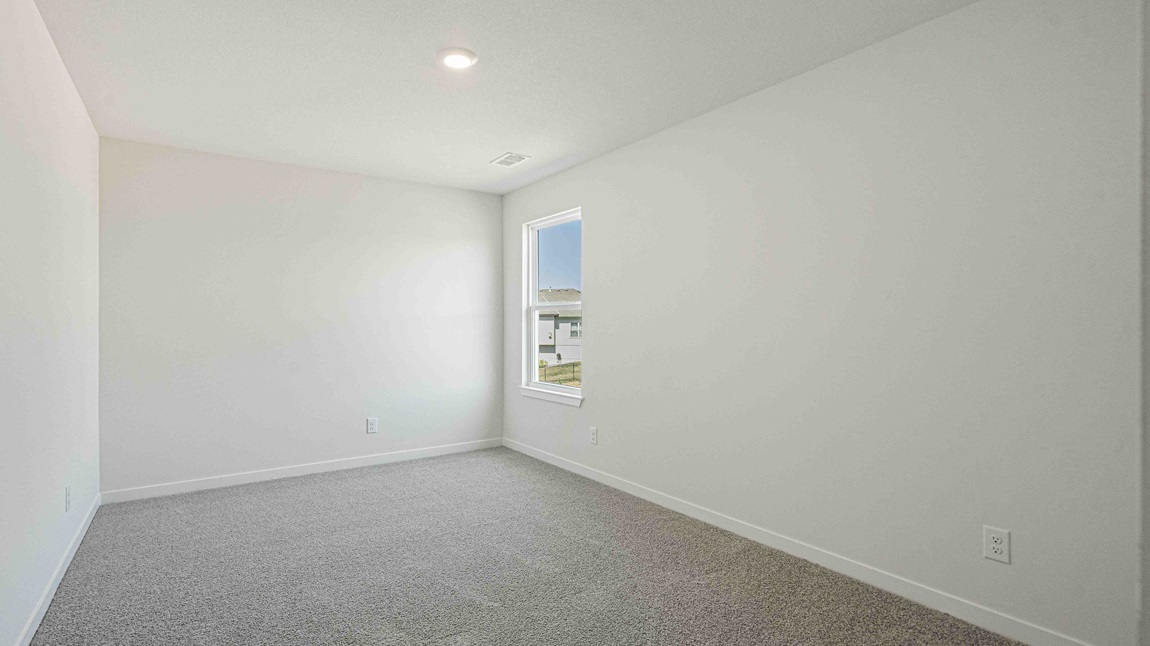 Large carpeted bedroom with window