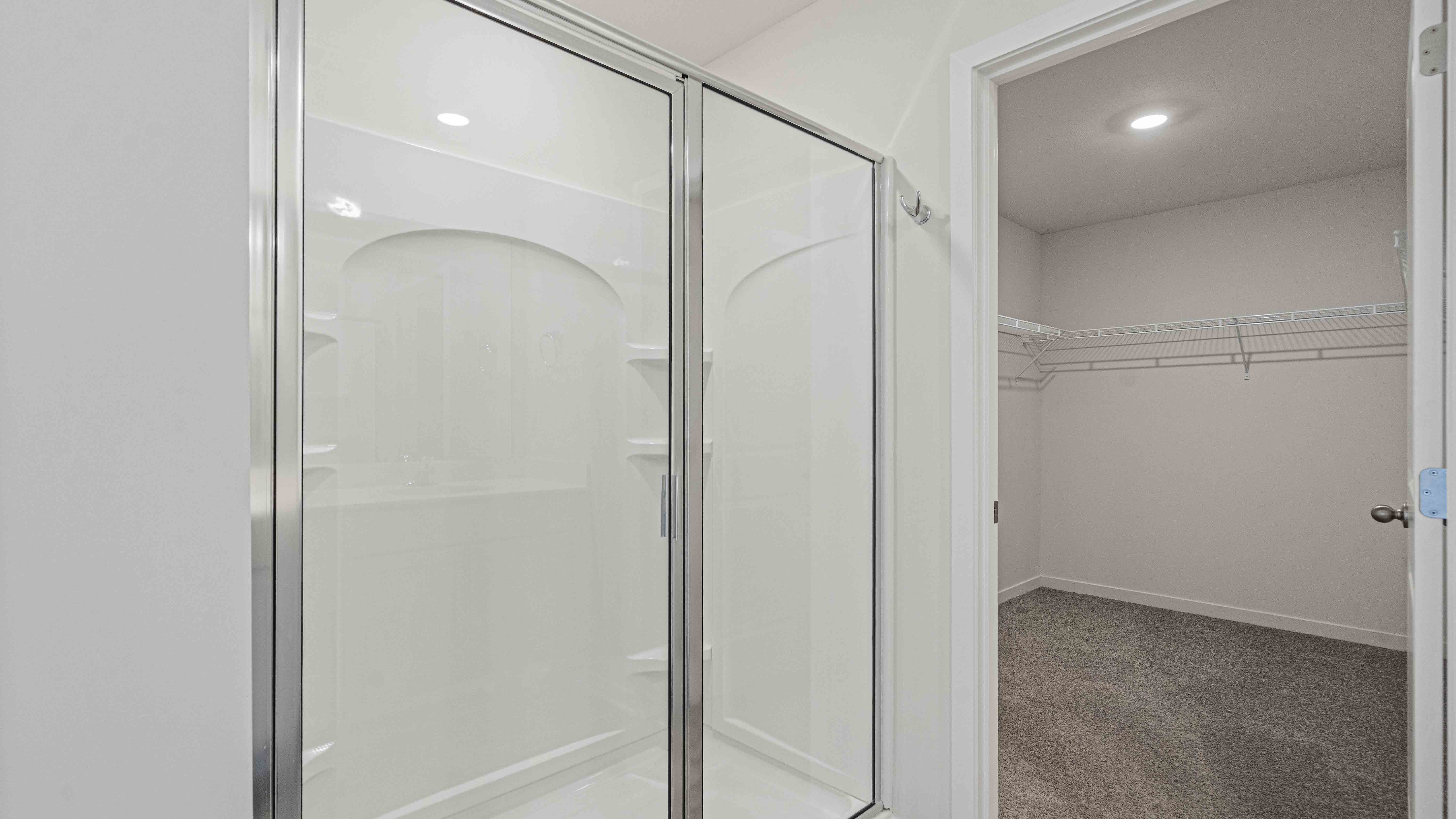 Primary bathroom with double vanity and glass door shower