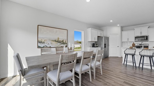 Dining area beside kitchen and living room with sliding glass back door and small window