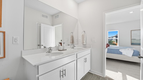 Pirmary bathroom with double sink vanity and standing glass door shower