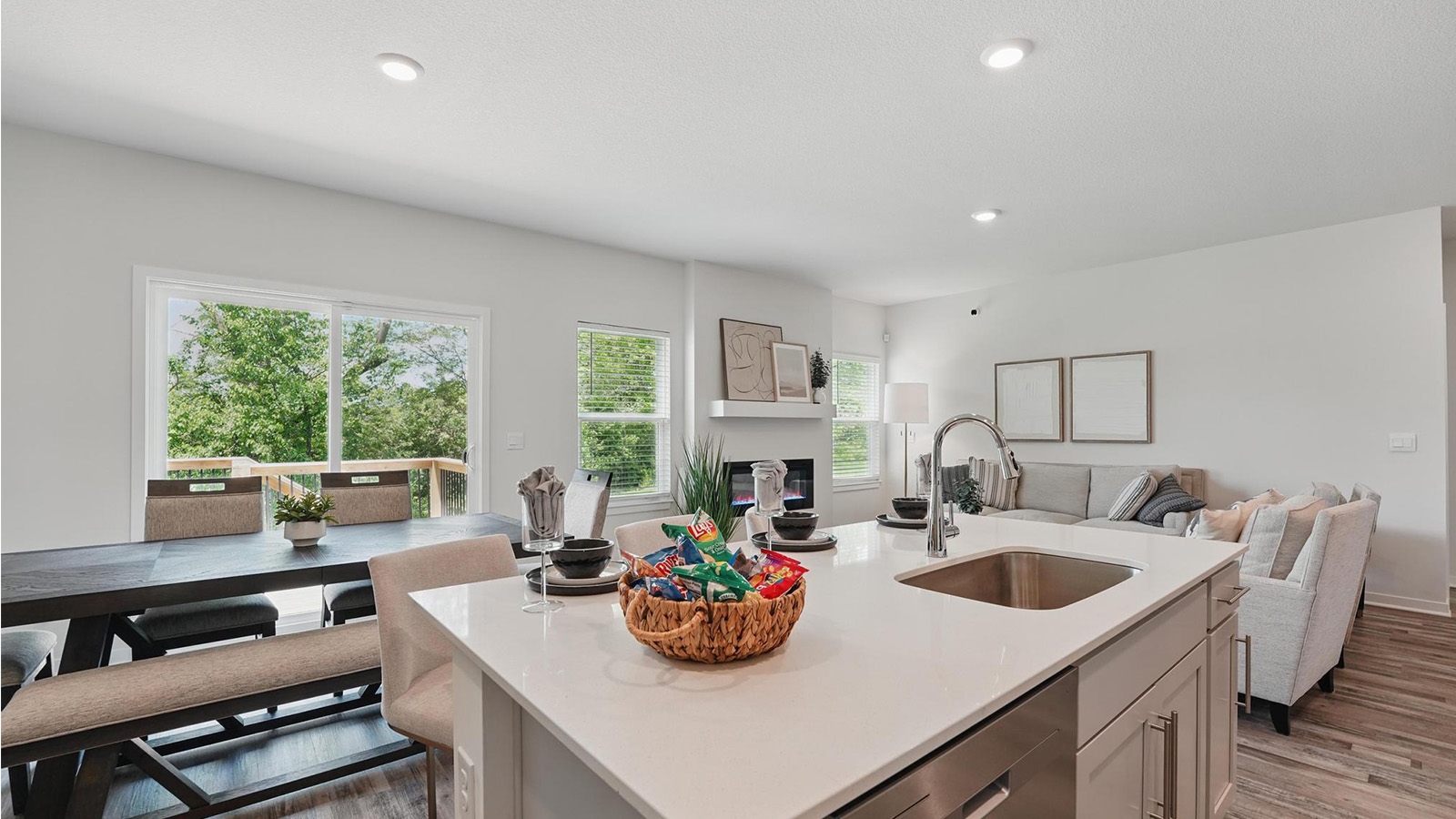 Kitchen and island with white cabinets and stainless steel appliances.