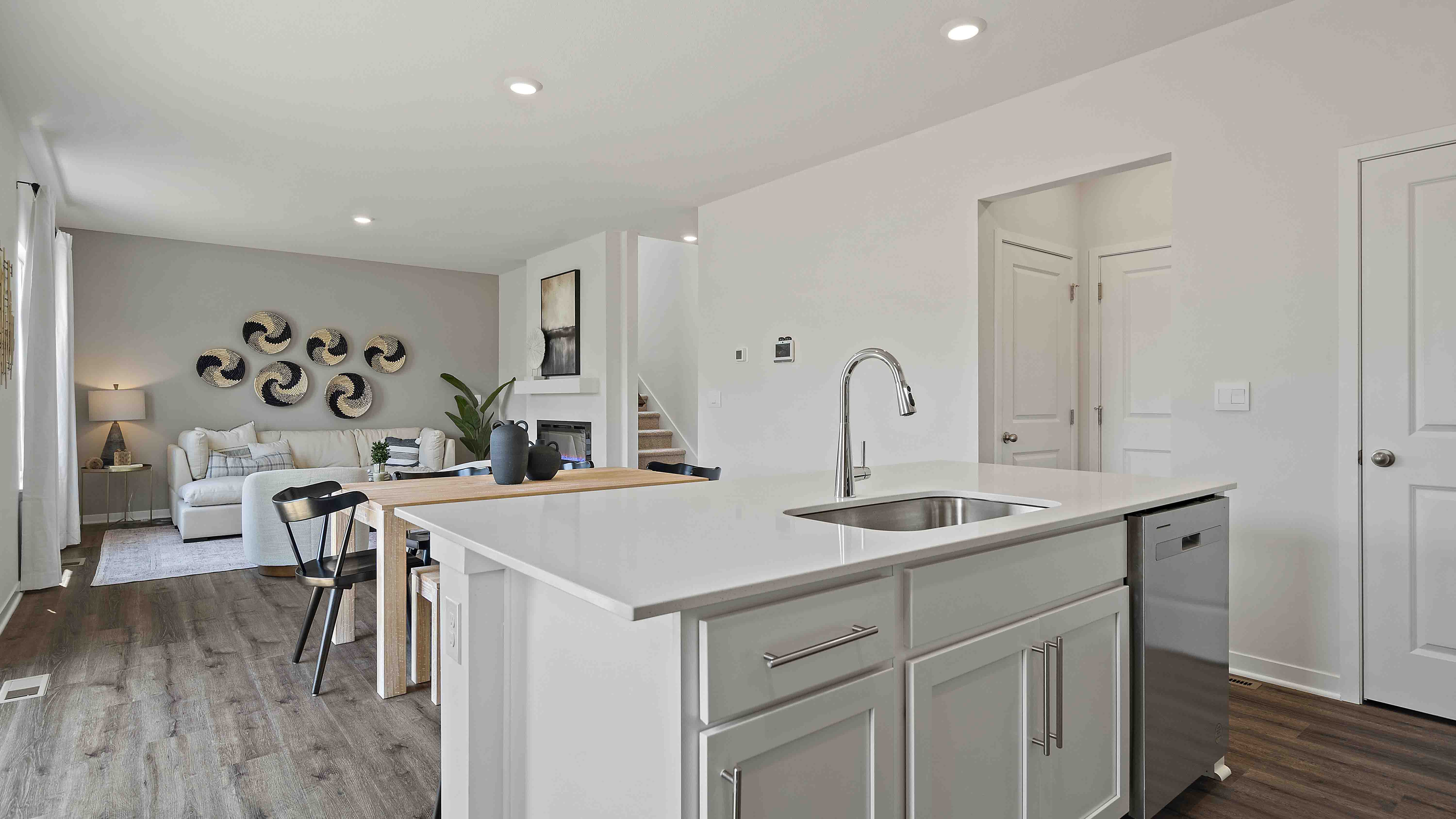 Kitchen and island with white cabinets and stainless steel appliances.