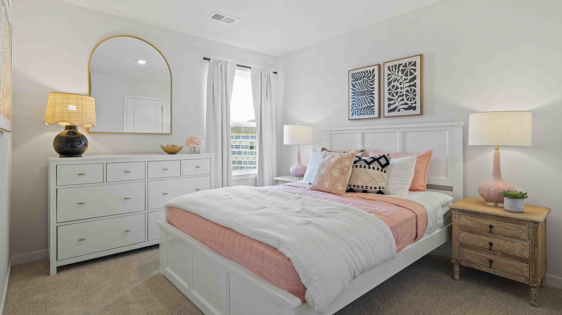 Carpeted bedroom with large window.