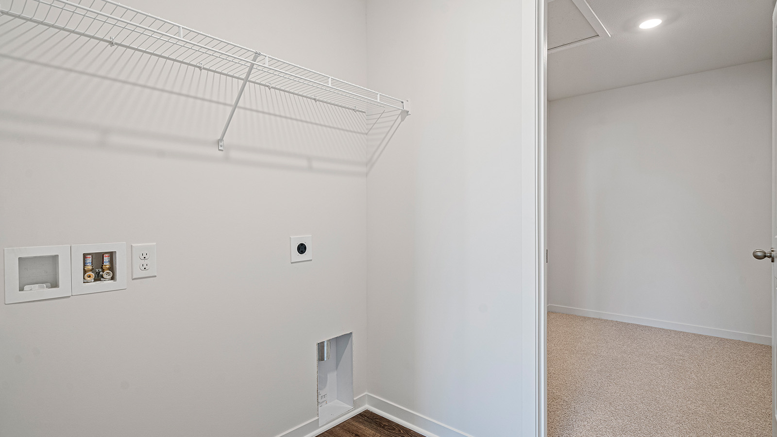 Laundry room with access to a walk-in closet.