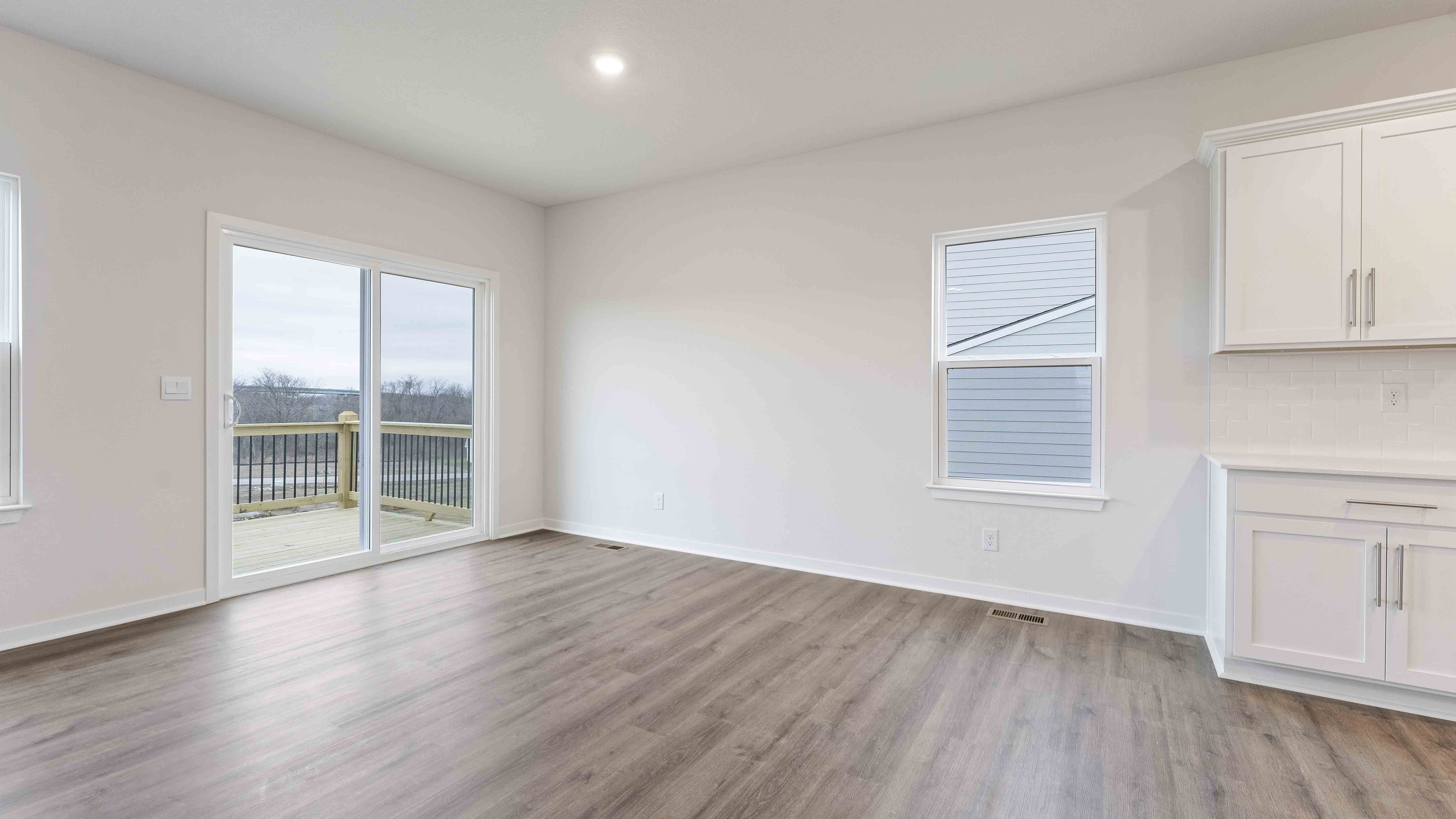 Dining area beside kitchen and living room with sliding glass back door and small window