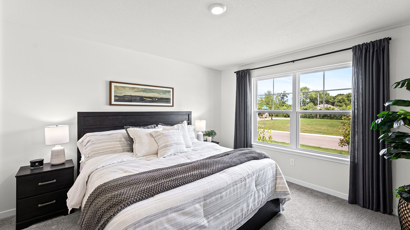 Carpeted primary bedroom with large windows