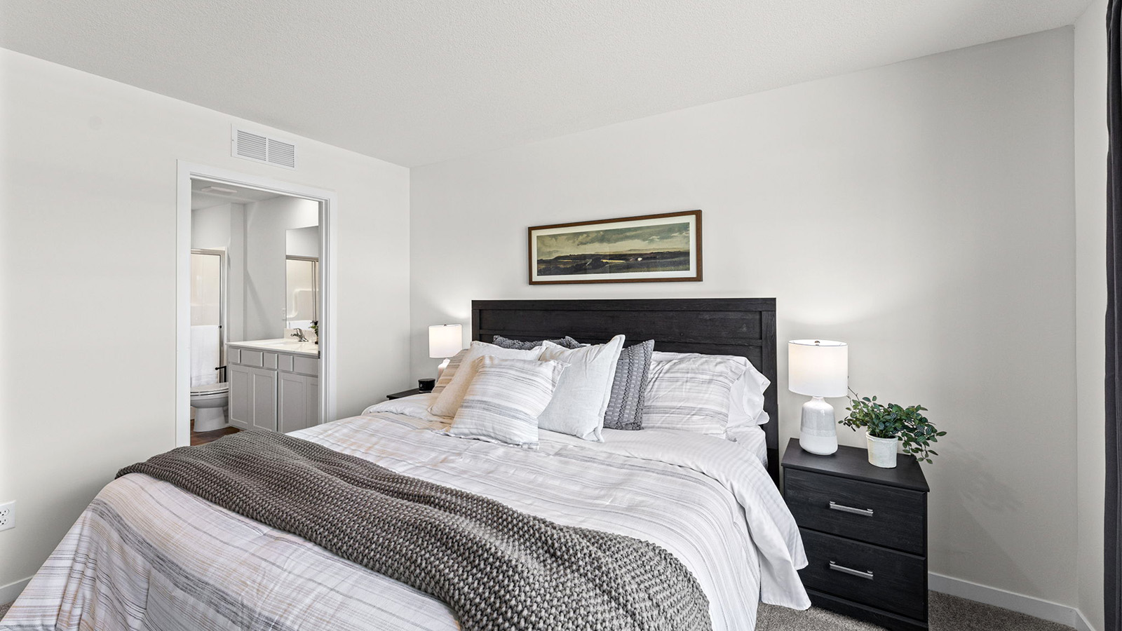 Carpeted primary bedroom with large windows
