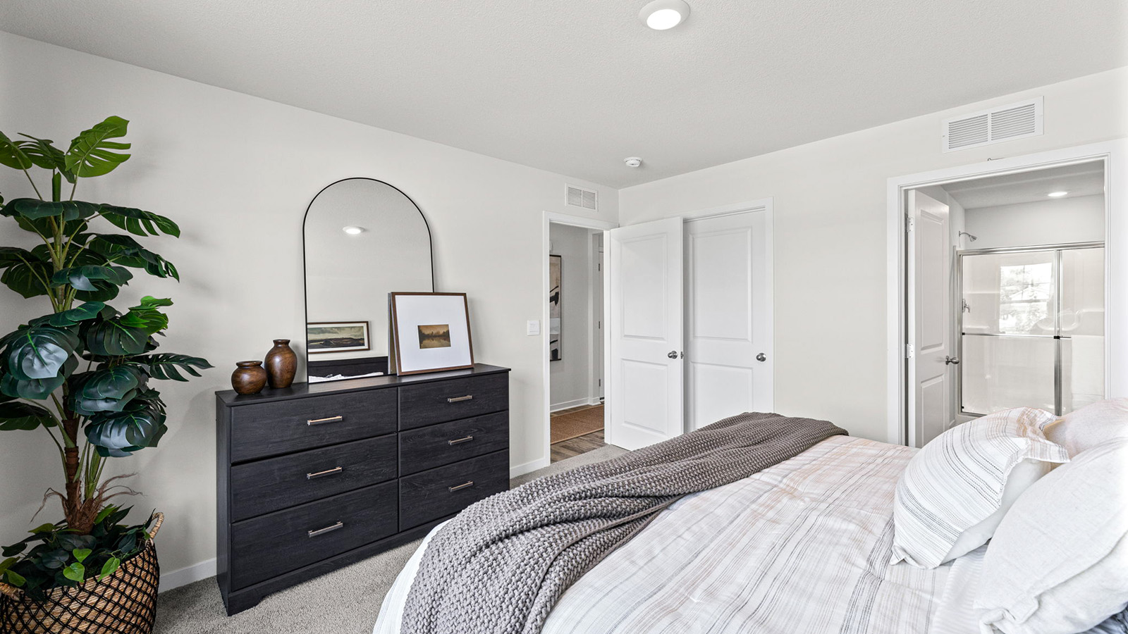 Carpeted primary bedroom with large windows