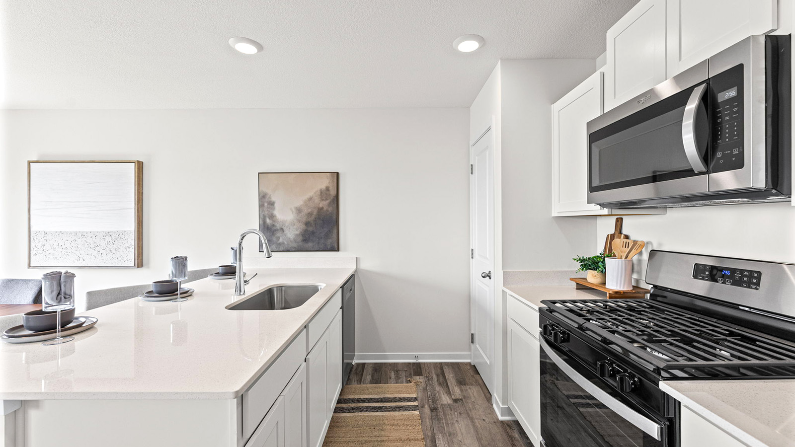 Open-concept kitchen with white counters and cabinets, and stainless steel appliances
