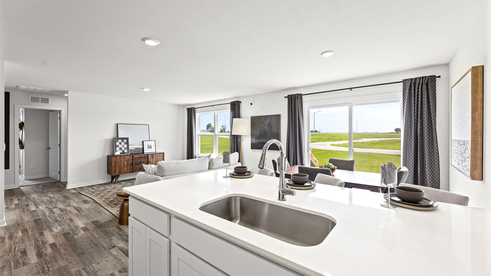Open-concept kitchen with white counters and cabinets, and stainless steel appliances