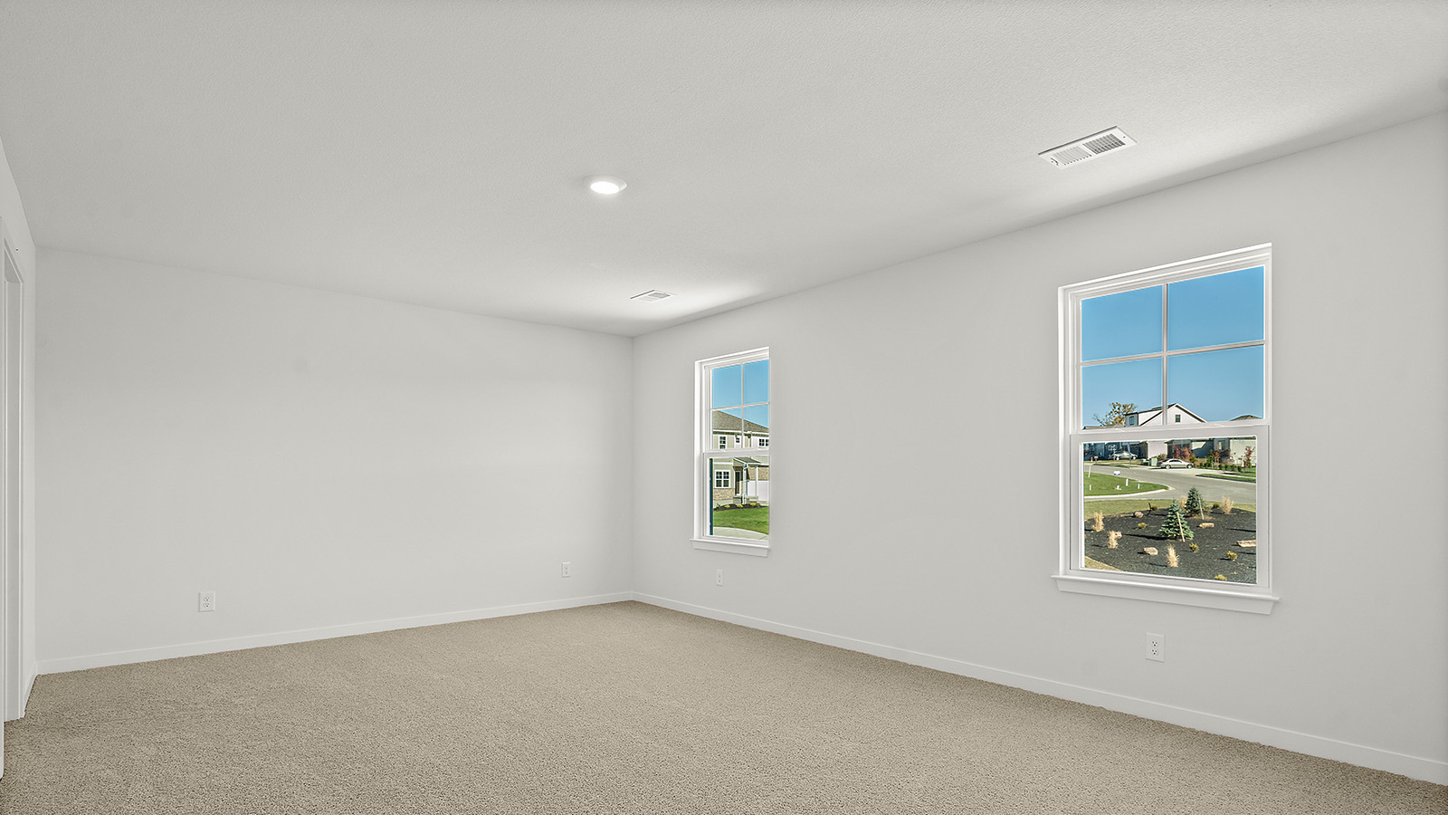 Carpeted primary bedroom with large windows and seating area. New Homes in Kansas City, Missouri