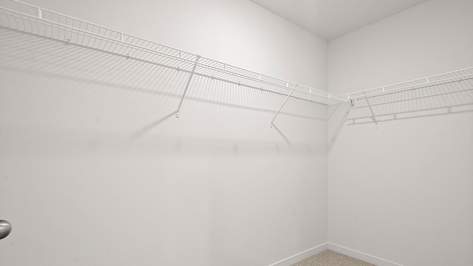 Carpeted primary bedroom with large windows and seating area. New Homes in Kansas City, Missouri