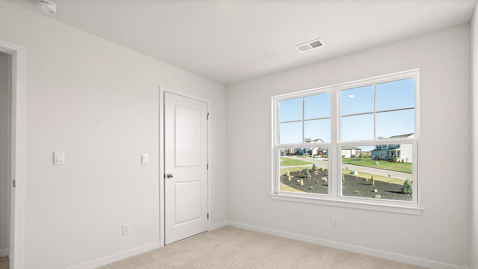 Carpeted bedroom with large window. New Homes in Kansas City, Missouri