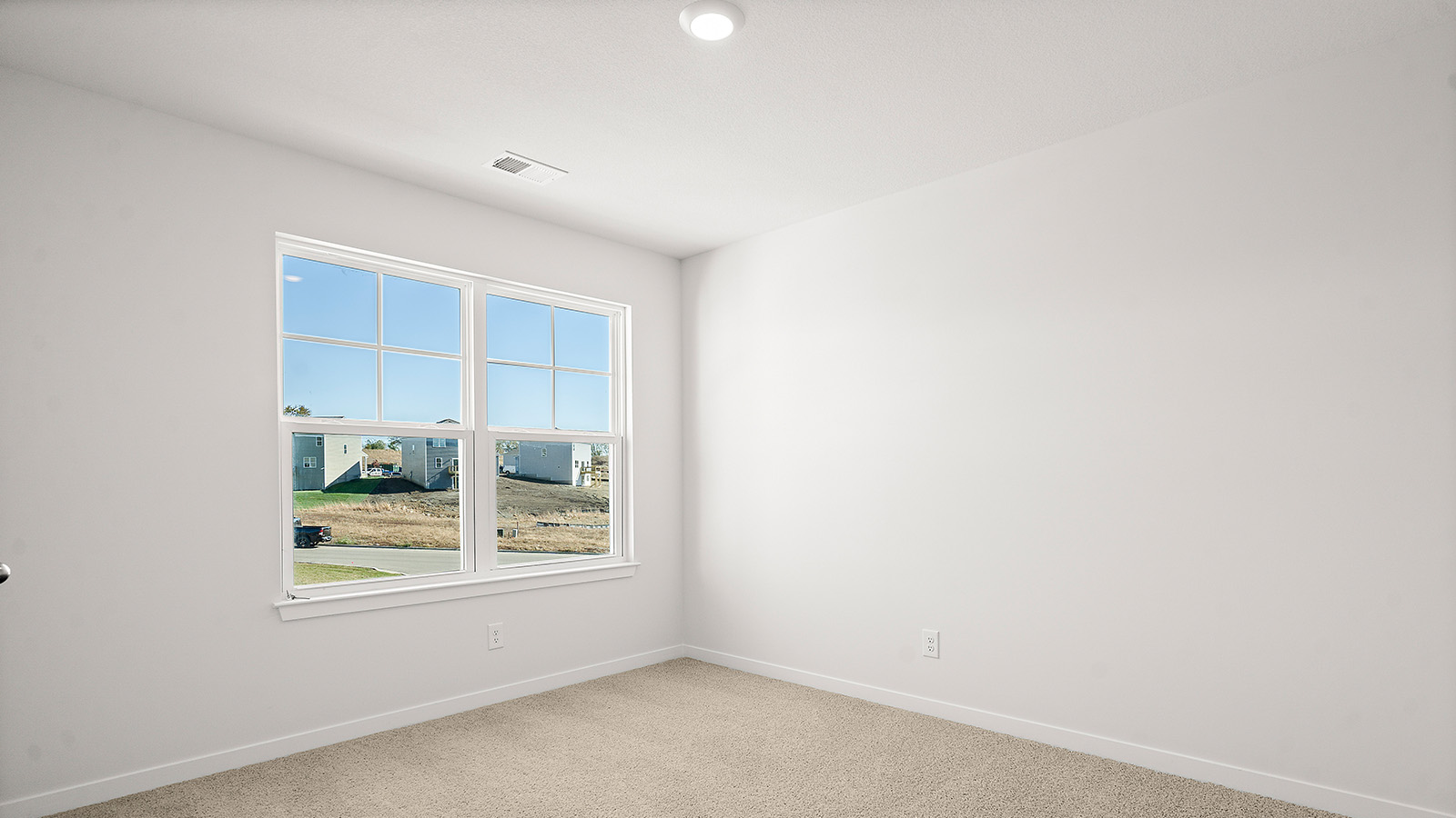 Carpeted bedroom with large window. New Homes in Kansas City, Missouri