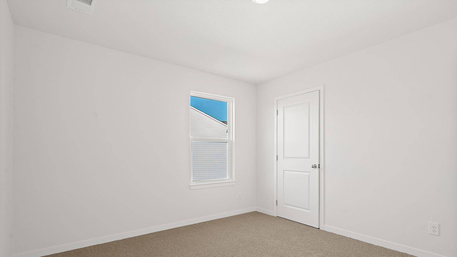 Carpeted bedroom with large window. New Homes in Kansas City, Missouri