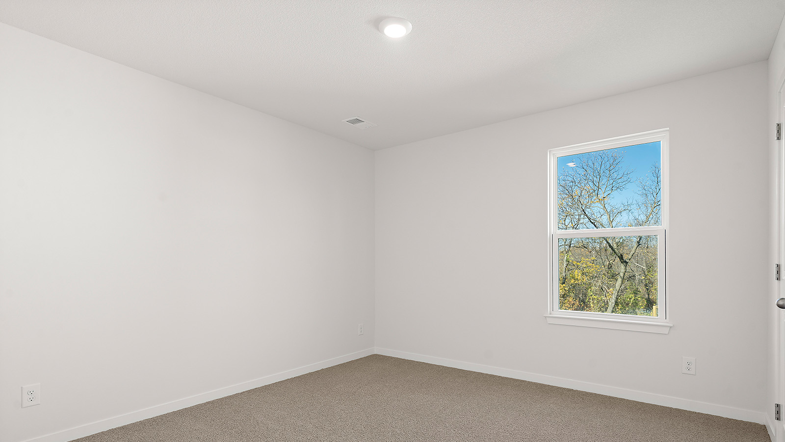 Carpeted bedroom with large window. New Homes in Kansas City, Missouri