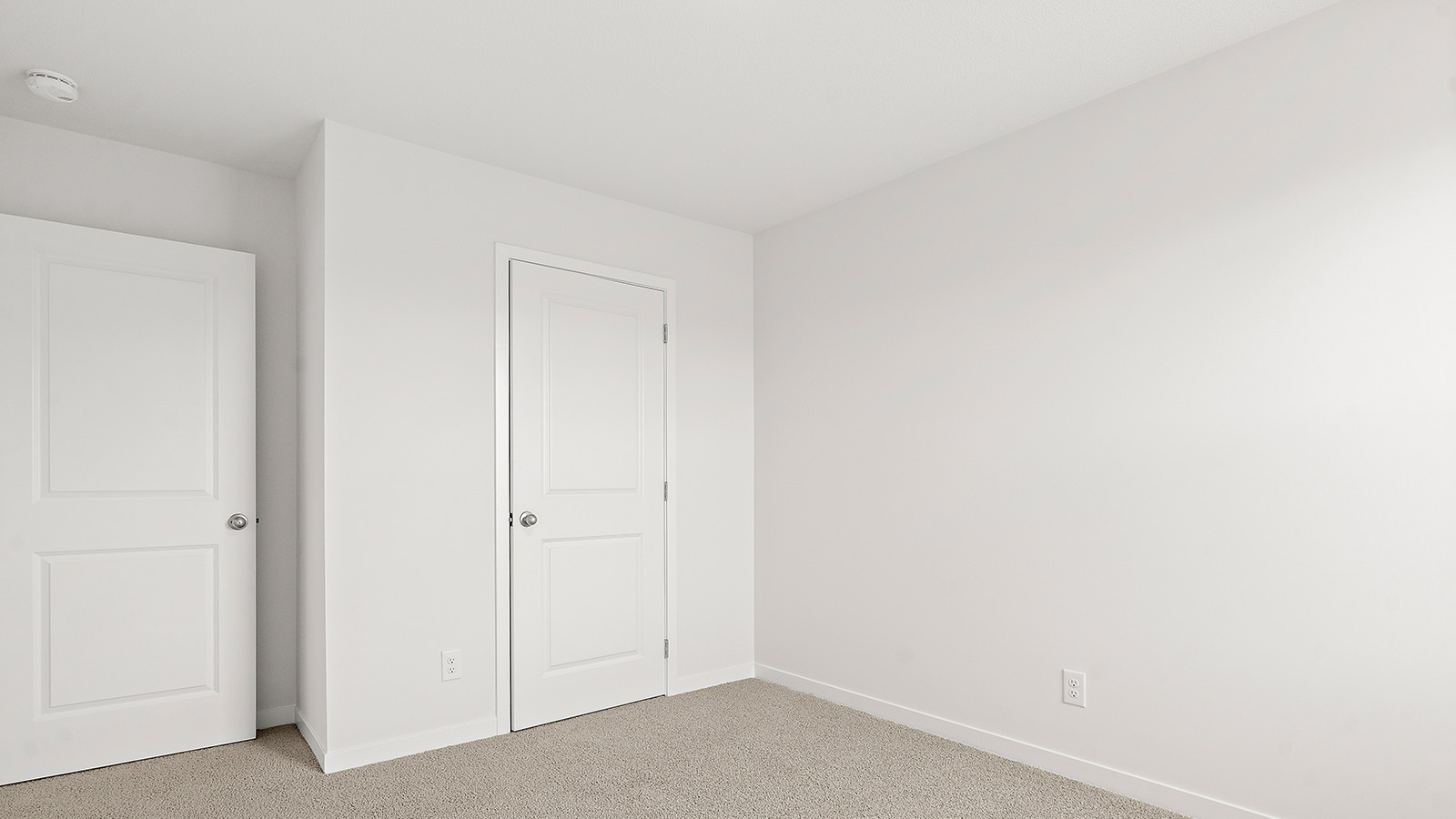 Carpeted bedroom with large window. New Homes in Kansas City, Missouri