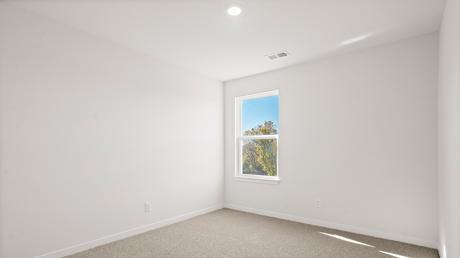 Carpeted bedroom with large window. New Homes in Kansas City, Missouri