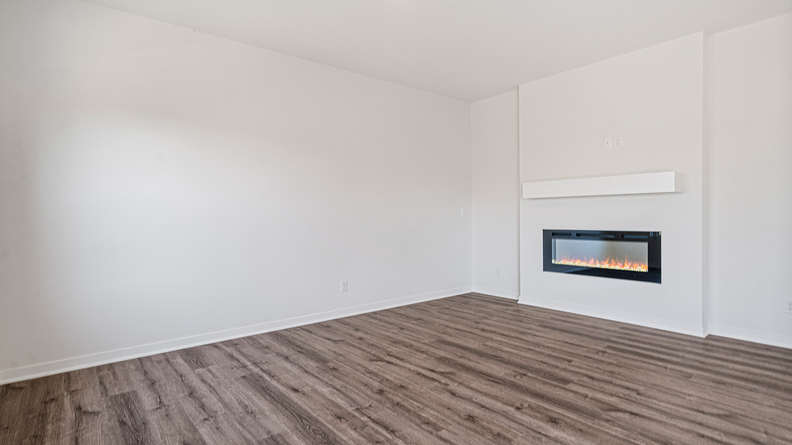 Living room beside kitchen, with electric fireplace and large windows