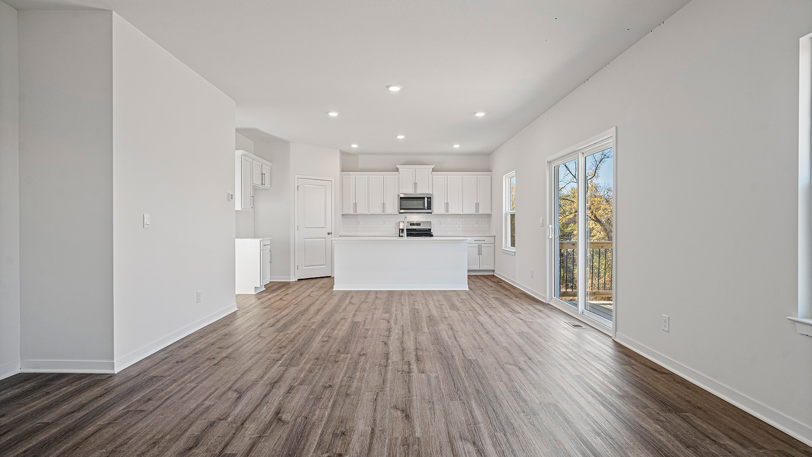 Living room beside kitchen, with electric fireplace and large windows