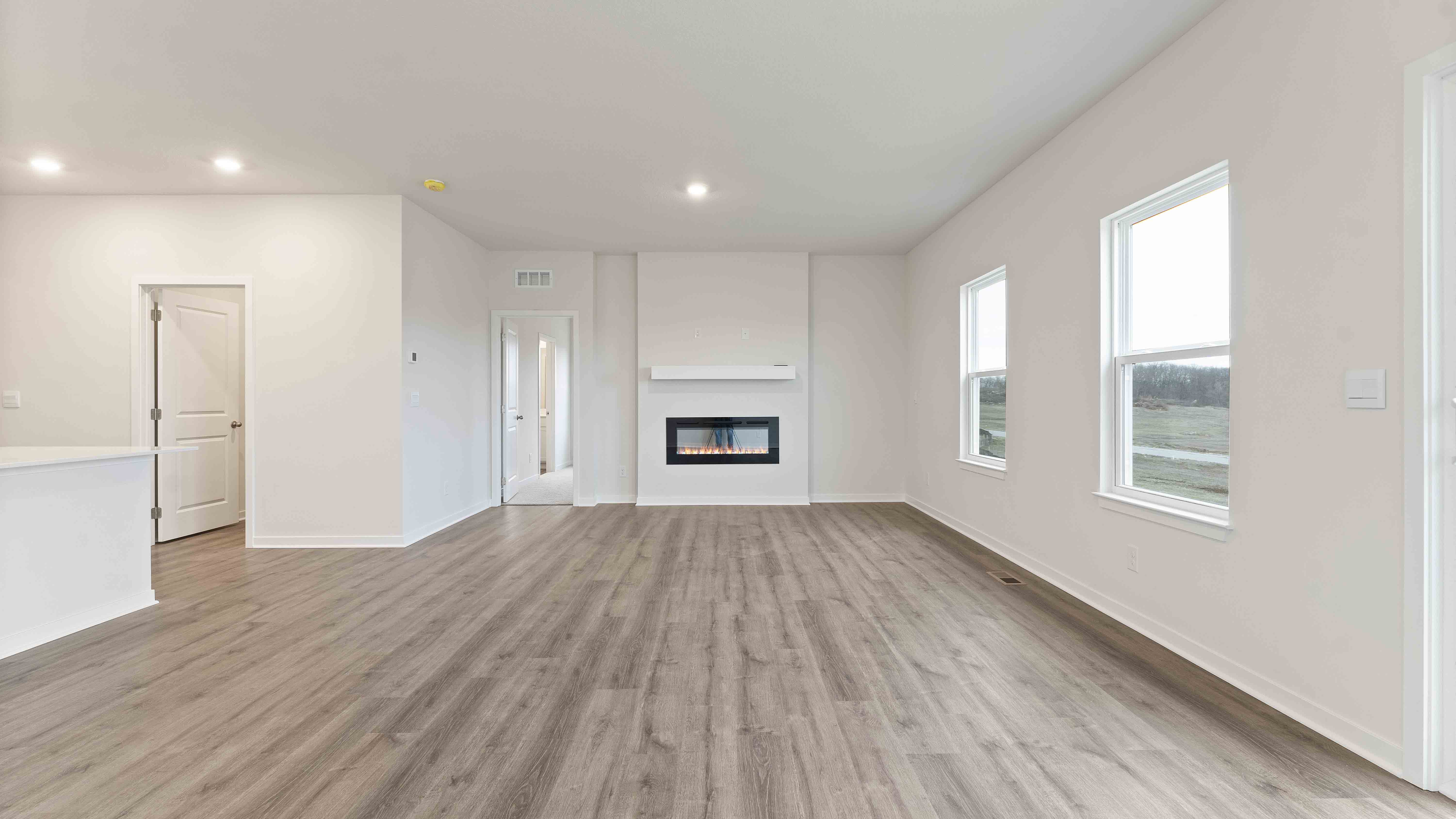 Open concept living area with large windows and fireplace