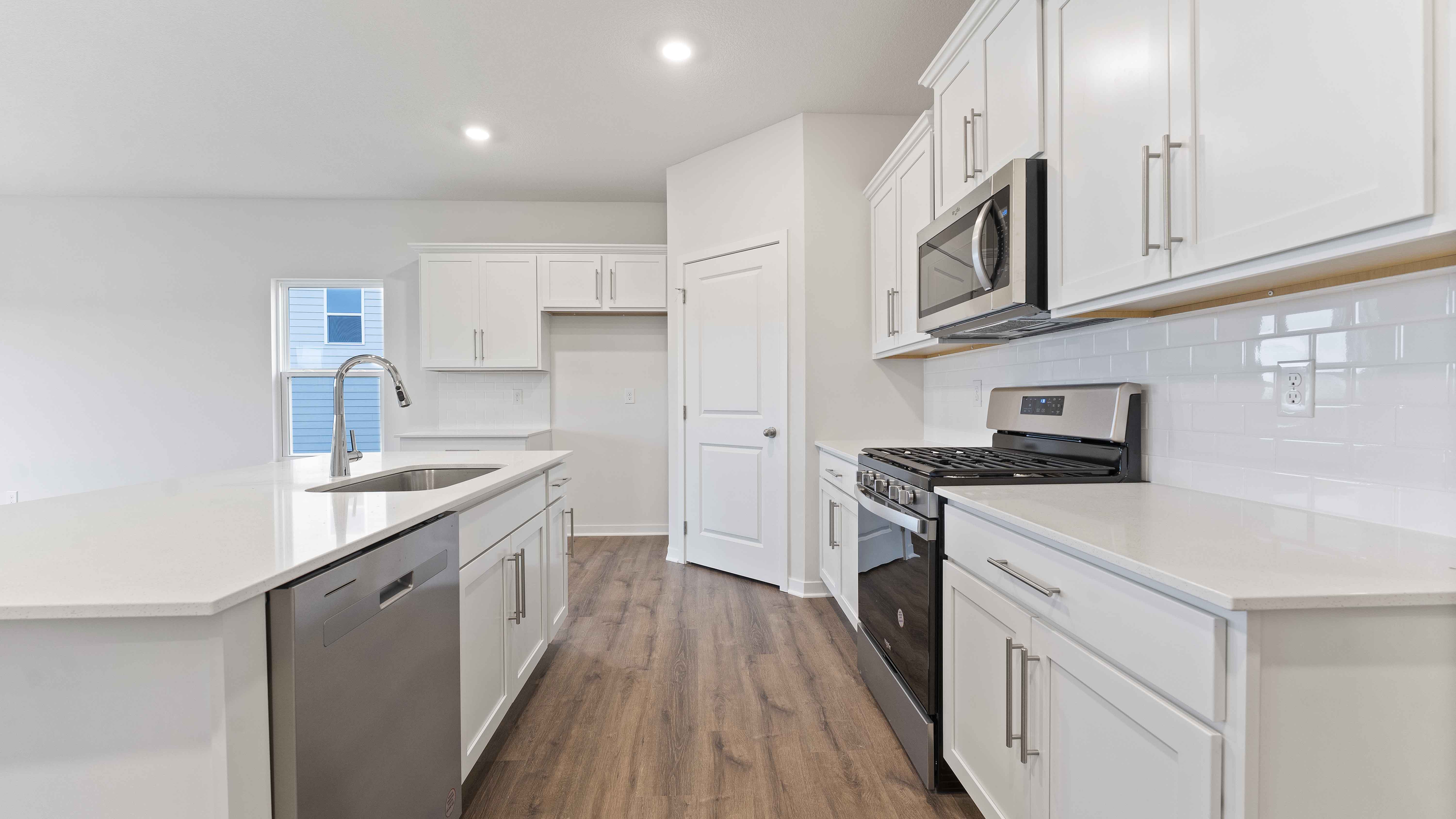 Kitchen with white cabinets and countertops and stainless steel appliances