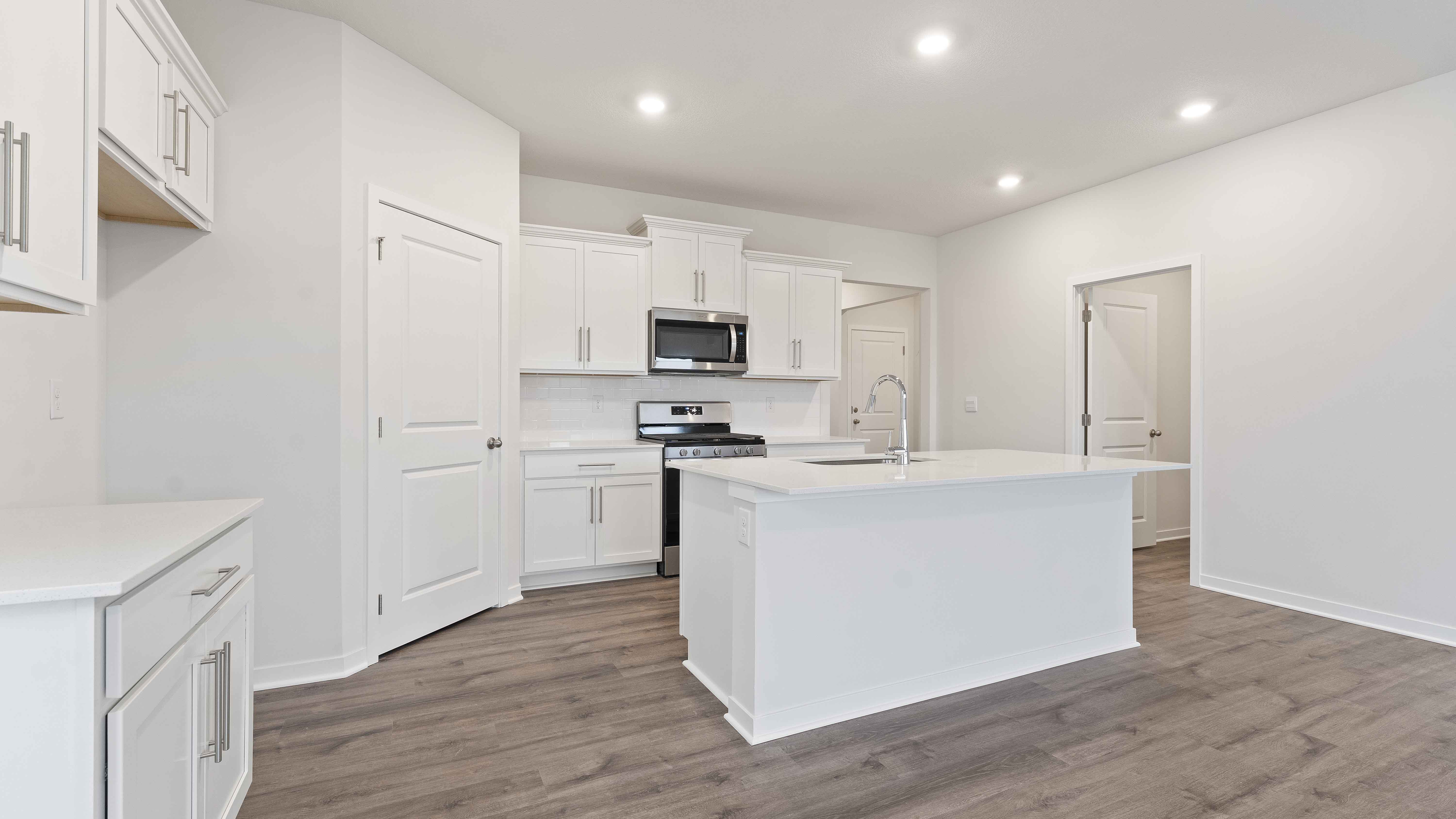 Kitchen with white cabinets and countertops and stainless steel appliances