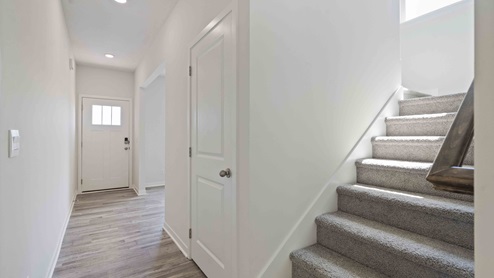 Welcoming foyer with view of carpeted staircase