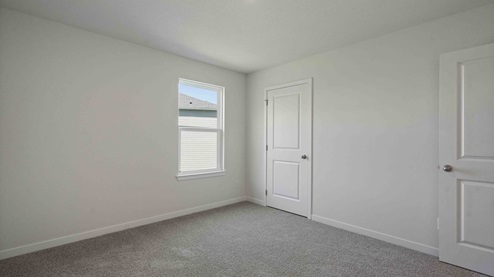 Carpeted bedroom with small window
