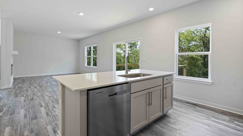 Kitchen and island with white cabinets, tile backsplash, and stainless steel appliances