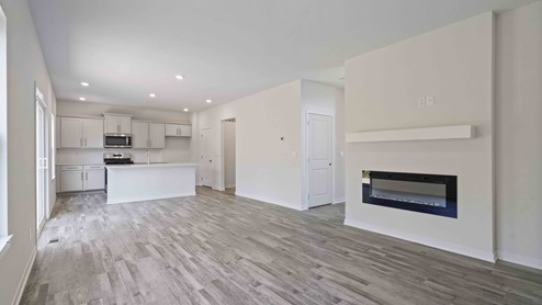 Living room beside kitchen, with electric fireplace and large window